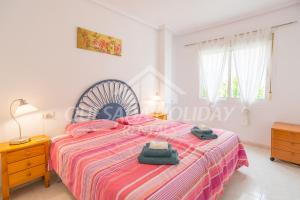 a bedroom with a large bed with a striped bedspread at Pancho Apartment Doña Pepa - C. Quesada in Rojales +32 photos