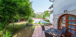 eine Terrasse mit Tisch und Stühlen und ein Pool in der Unterkunft Gorgeous Hideout in Mostar