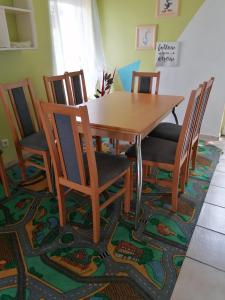 a dining room with a table and chairs on a rug at Domek 8 osobowy PORTOWA PRZYSTAŃ 150m od plaży in Mrzeżyno