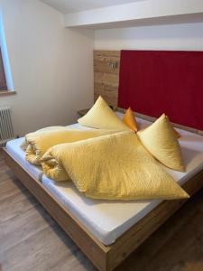 a bed with yellow blankets and pillows on it at Rimls Landhaus in Sölden
