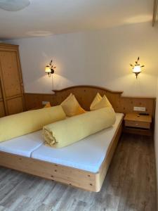 a bedroom with a wooden bed with pillows on it at Rimls Landhaus in Sölden