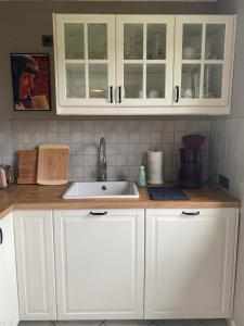 a kitchen with white cabinets and a sink at Ferienhaus Waldhaus in Grafenau