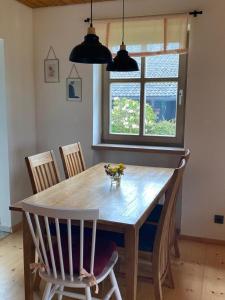 einen Esstisch mit Stühlen und ein großes Fenster in der Unterkunft Ferienhaus Waldhaus in Grafenau