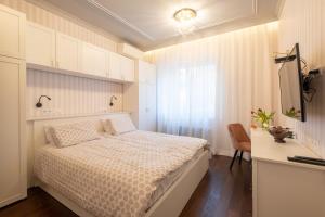 Habitación pequeña con cama y escritorio. en Premium Apartments - Top-Notch Place 2BR/2BTH, en Sofía