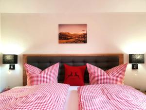 - une chambre avec 2 lits dotés de draps en damier rouge et blanc dans l'établissement Ferienwohnungen Alpspitzecho, à Garmisch-Partenkirchen