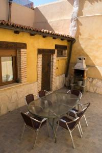d'une terrasse avec une table, des chaises et un four. dans l'établissement Vivienda Turistica El Caneco, à Tordesillas