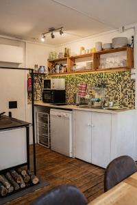 Kunderi 16 Holiday House في راكفيري: مطبخ صغير مع دواليب بيضاء واجهزة