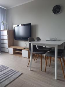 a living room with a table and chairs and a television at Apartament 26 in Drawsko Pomorskie
