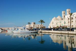 two boats are docked in a harbor with buildings at B&B re apartments Palazzo Muscati in Molfetta