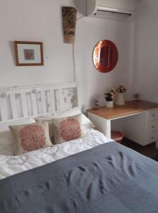 a bedroom with a white bed with pillows and a table at Casita Adela in Huéscar