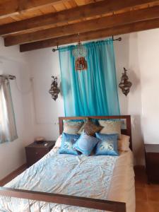 a bedroom with a bed with blue curtains at Casita Adela in Huéscar