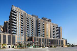 een groot appartementencomplex met een parkeerplaats ervoor bij Aparthotel Adagio Dubai Deira in Dubai