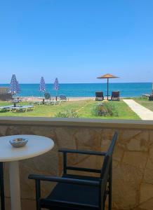 a table and chairs with the ocean in the background at Ermis Suites in Platanias