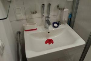 a white bathroom sink with a red face on it at Mini apartment in fairy-tale city! in Heidelberg