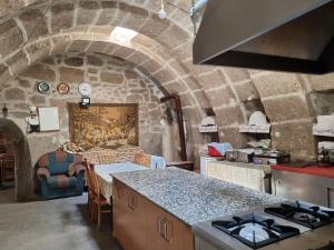 a kitchen with a stone wall and a counter top at Guest House Sunlight in Guzelyurt