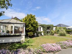 a house with a garden with flowers in the yard at Beach Bungalow in Rhyl