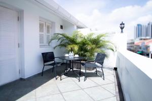 a patio with a table and chairs on a balcony at Harbour Ville Hotel - Hamilton in Singapore