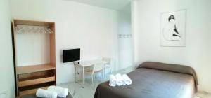 a bedroom with a bed and a table and a television at L'Altare Bianco in Vieste