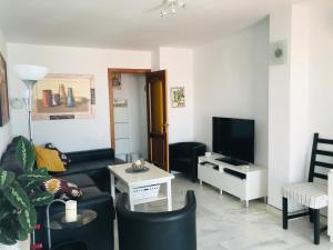 a living room with a couch and a tv at Casa Competa Centro in Cómpeta