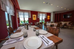 ein Restaurant mit einem langen Tisch mit Tellern und Servietten in der Unterkunft Fiore Hotel in Kavajë