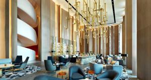 クウェートにあるFour Seasons Hotel Kuwait at Burj Alshayaのロビー(椅子、テーブル、シャンデリア付)