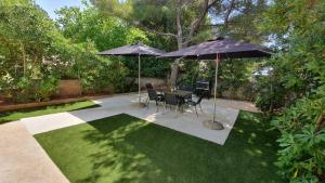 a patio with a table and two umbrellas at Holiday Home Darko in Novalja