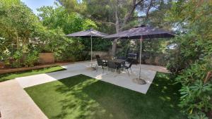 a patio with a table and two umbrellas at Holiday Home Darko in Novalja