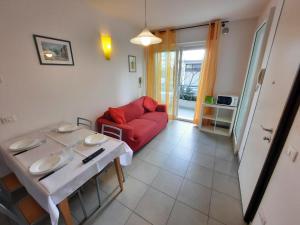 a living room with a red couch and a table at Residence El Patio in Lido di Jesolo +39 photos