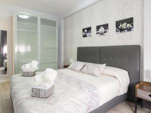 - une chambre dotée d'un grand lit blanc avec deux paniers dans l'établissement Click&Flat Xoriguer, à Barcelone