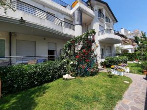 a house with a bush with flowers in the yard at Residence El Patio in Lido di Jesolo
