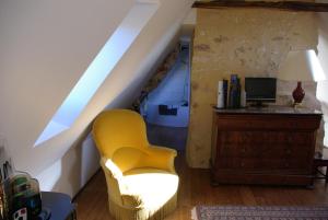 a living room with a yellow chair and a desk at Péchalvet in Fleurac