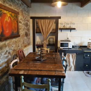 a kitchen with a wooden table in a room at Al Alba Alojamiento Rural in Illas