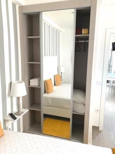 uno specchio in una stanza con un letto e una lampada di Duarte Houses - Casa T1 N - com vista mar a Nazaré