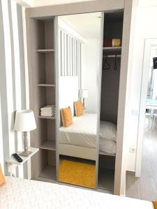 einen Spiegel in einem Zimmer mit einem Bett und einer Lampe in der Unterkunft Duarte Houses - Casa T1 N - com vista mar in Nazaré