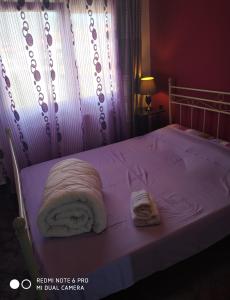 uma cama com um cobertor branco e duas toalhas em La betia em Litochoro