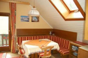 um quarto com uma mesa, um banco e uma janela em Zur alten Schmiede em Bad Kleinkirchheim