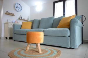 un sofá azul con una silla naranja en la sala de estar en Villa Sangemi en Àrbatax