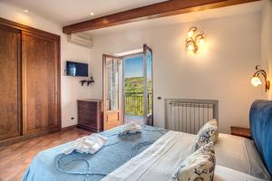 1 dormitorio con 1 cama y puerta a un balcón en Mattia, en SantʼAgata sui Due Golfi