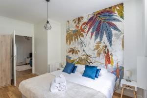 聖馬洛的住宿－Les Lauriers - dans l'Intramuros，卧室配有带蓝色枕头的大型白色床