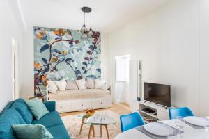 sala de estar con sofá y TV en Les Lauriers - dans l'Intramuros, en Saint-Malo