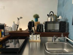 a kitchen counter with a sink and a microwave at Casa Velata a Spaccanapoli in Naples
