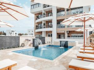 a swimming pool with a fountain and two umbrellas at Onyx Luxury in Ulcinj