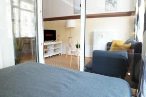 a bedroom with a blue bed and a living room at FULL HOUSE Studios - Westside Apartment - Nescafé inkl in Leipzig