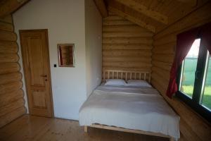 ein Schlafzimmer mit einem Bett in einem Blockhaus in der Unterkunft Christiana-Rent in Cristian
