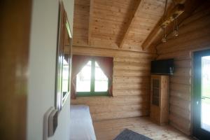Zimmer mit einer Holzwand und einem Fenster in der Unterkunft Christiana-Rent in Cristian