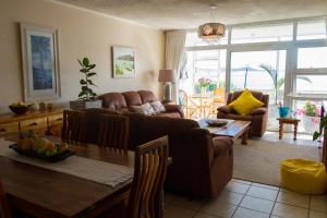 a living room with a couch and a table at Bayview Seafront Apartment in East London