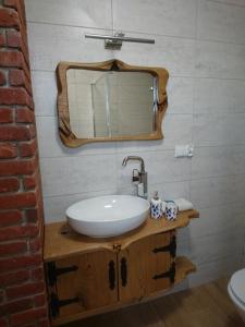 a bathroom with a sink and a mirror at Mazurska Chatka Puchatka in Piecki