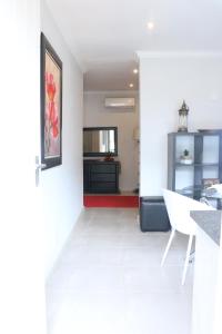 een keuken en een woonkamer met een witte tegelvloer bij Millennium Body Guards Guesthouse in Hartbeespoort
