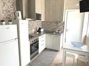 una cucina con mobili bianchi e un forno a piano cottura di Duarte Houses - Casa T1 N - com vista mar a Nazaré