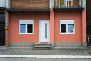 a orange building with two windows and a white door at CITY APARTMENT BB in Bajina Bašta